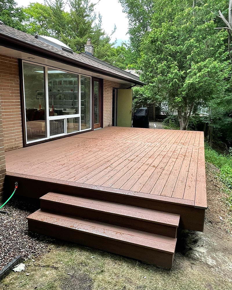Low composite deck with steps off a brick home